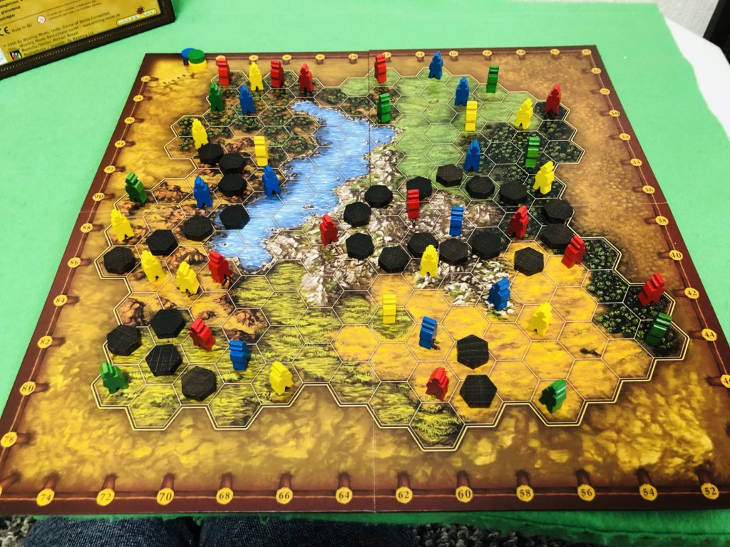 ボードゲーム『テラノバ』のプレイ風景。地図の上に3色の駒が広がり綺麗な盤面